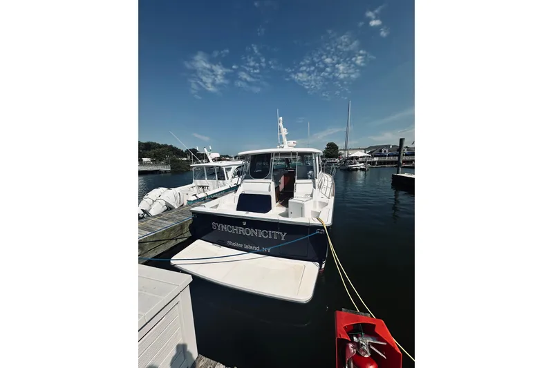 Slide: The Image of 2007 Sabre 34 Express boat docked at marina under clear blue sky. - 115