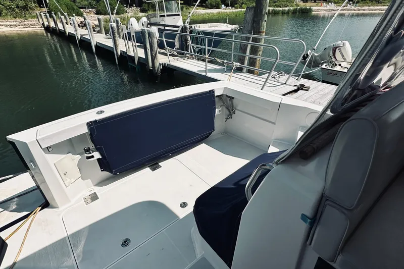 Slide: The Image of 2007 Sabreline 34 Express boat interior at dock, featuring seating and railing. - 16