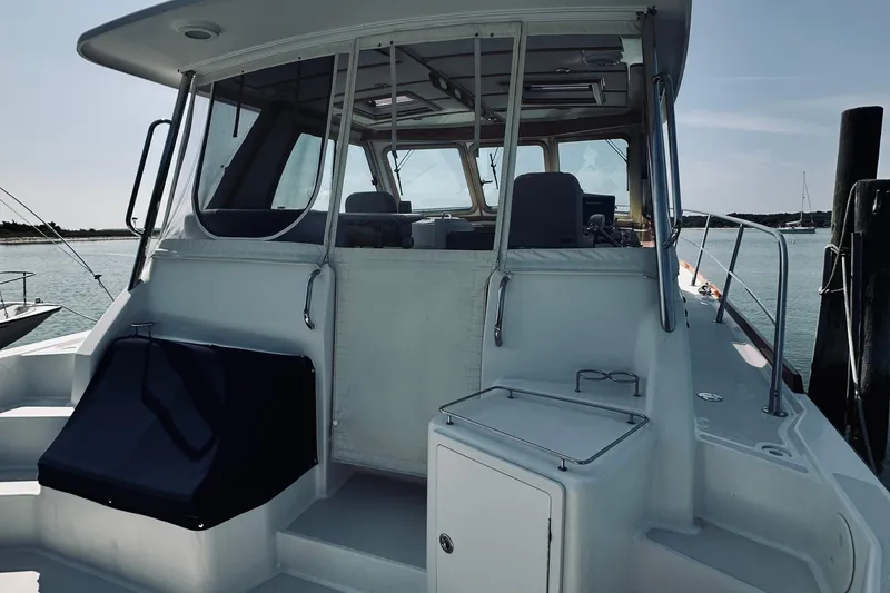 Slide: The Image of 2007 Sabreline 34 Express boat docked, showcasing rear deck and cabin entrance. - 22