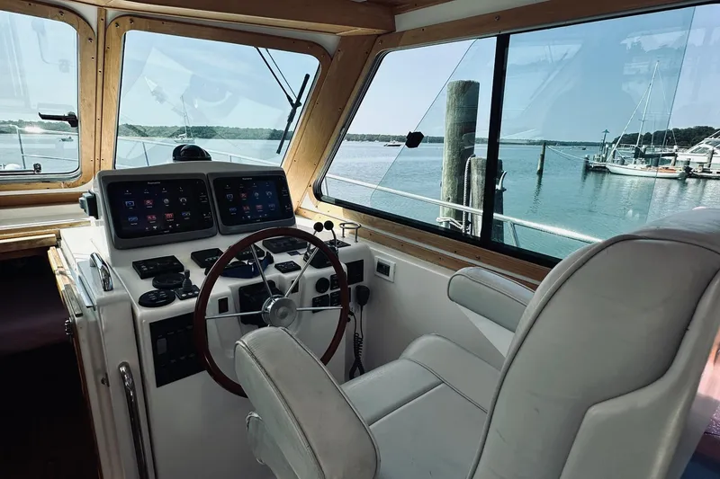 Slide: The Image of 2007 Sabreline 34 Express helm with modern controls and scenic marina view. - 40