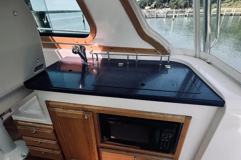 Slide: The Image of 2007 Sabreline 34 Express yacht interior with kitchenette, featuring sink and microwave. - 44