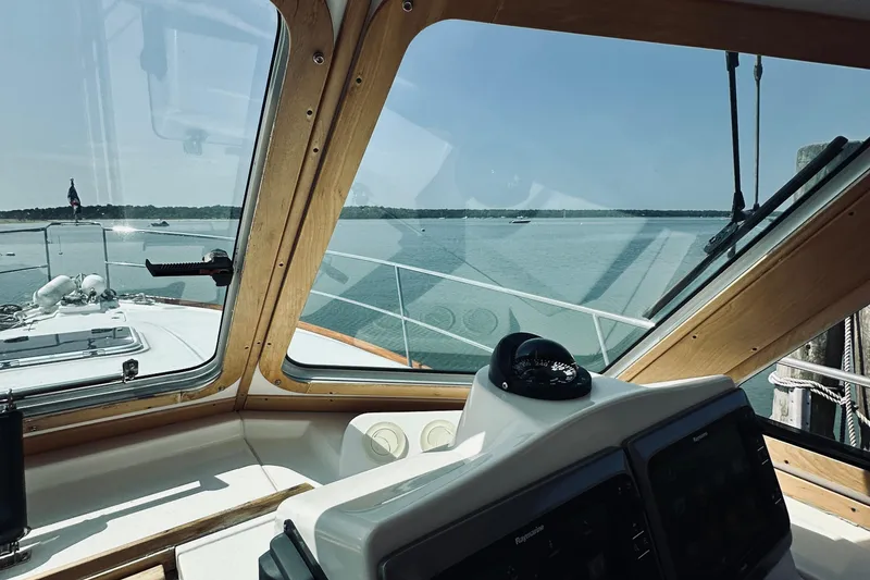 Slide: The Image of 2007 Sabreline 34 Express helm view with scenic water backdrop. - 47