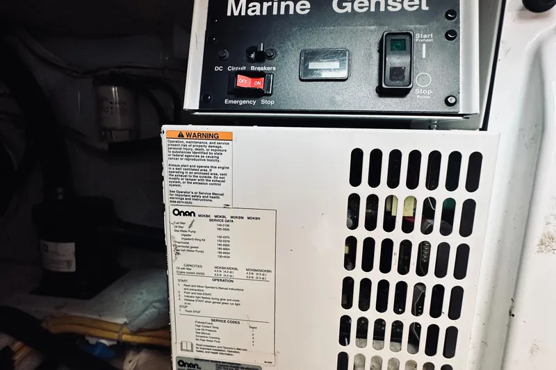 Slide: The Image of 2007 Sabreline 34 Express marine generator control panel with warning label and specifications. - 85
