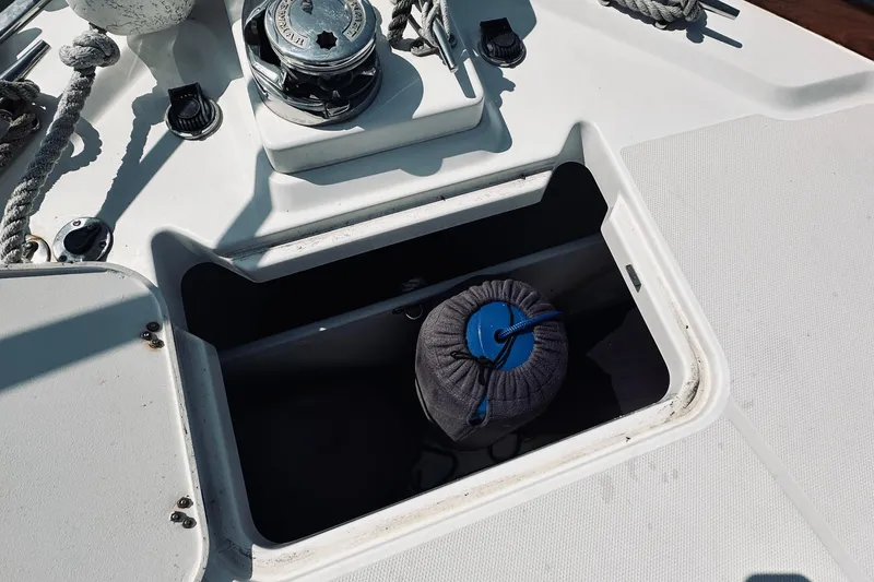 Slide: The Image of 2007 Sabreline 34 Express boat deck with open storage compartment and winch. - 93