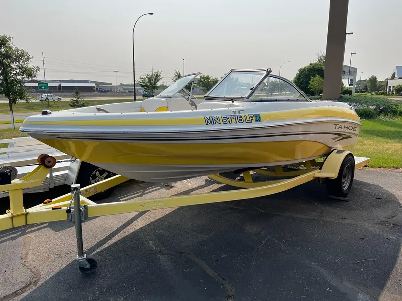 Slide: The Image of Yellow 2006 Tahoe Q4 boat on trailer, parked outdoors on a sunny day. - 3