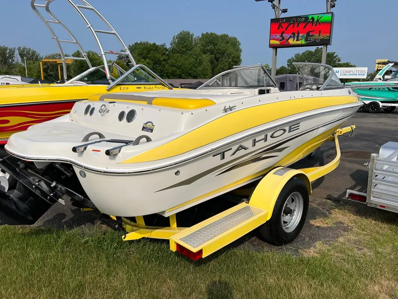Slide: The Image of 2006 Tahoe Q4 boat with yellow accents on a trailer, parked outdoors. - 4