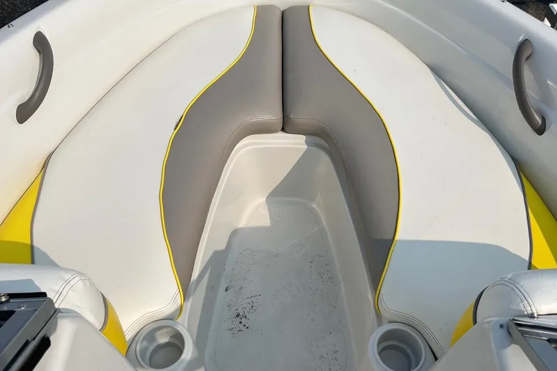 Slide: The Image of 2006 Tahoe Q4 boat interior with gray and yellow seating, cup holders, and grab handles. - 9