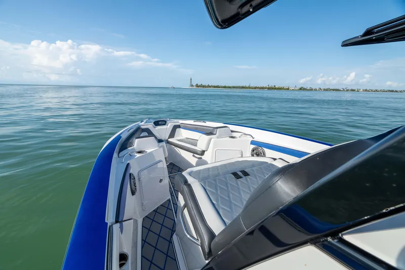 Slide: The Image of 2020 Sunsation 32 CCX boat interior with blue accents and speaker, under clear sky. - 21