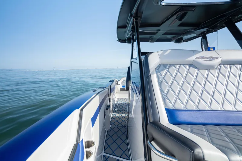 Slide: The Image of 2020 Sunsation 32 CCX boat interior with blue and white seating on open water. - 30