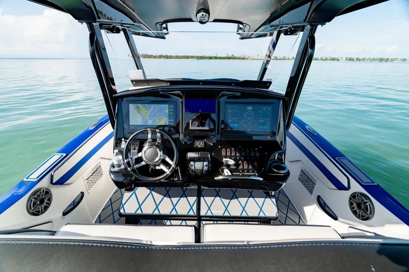 Slide: The Image of 2020 Sunsation 32 CCX boat interior with luxurious seating and steering wheel, on calm water. - 8