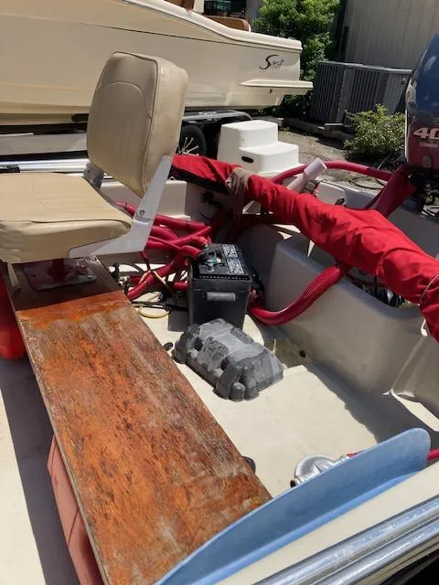 Slide: The Image of 1980 Boston Whaler 13 interior with seating, battery, and engine components. - 4