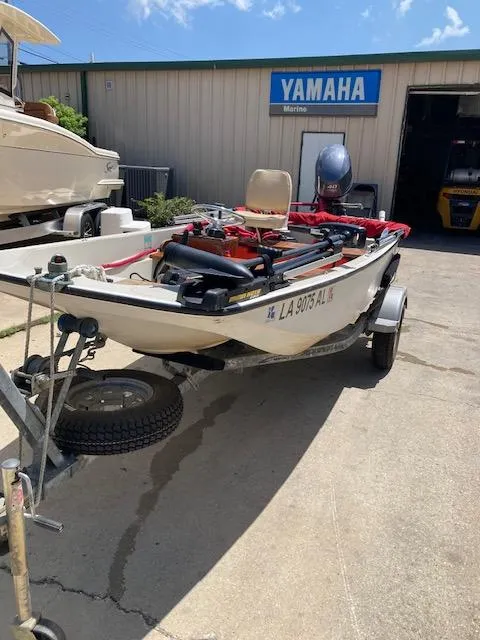 Slide: The Image of 1980 Boston Whaler 13 boat on trailer, parked outside Yamaha Marine shop. - 5
