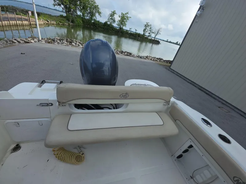 Slide: The Image of 2018 NauticStar 22 XS Offshore boat with seating and outboard motor by a waterfront. - 14