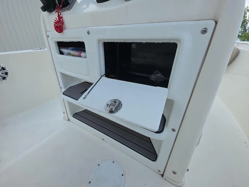 Slide: The Image of 2018 NauticStar 22 XS Offshore boat storage compartments and control panel. - 9