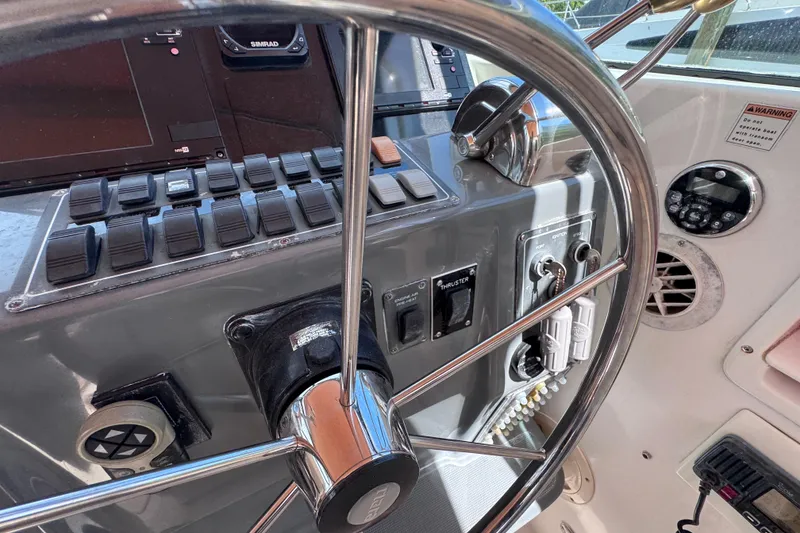 Slide: The Image of Control panel of a 2001 Tiara Yachts 3100 Open, featuring steering wheel and switches. - 22