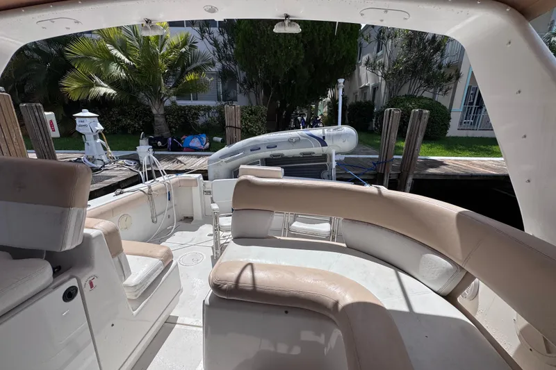 Slide: The Image of 2001 Tiara Yachts 3100 Open interior with seating and docked inflatable boat. - 27