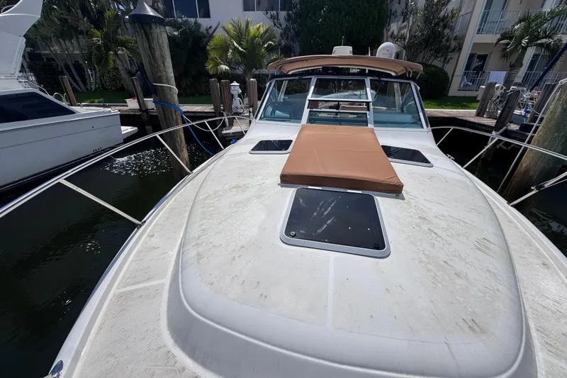Slide: The Image of 2001 Tiara Yachts 3100 Open docked, featuring spacious deck and sunpad. - 34