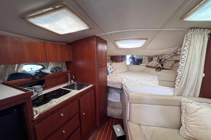 Slide: The Image of Interior of 2001 Tiara Yachts 3100 Open, featuring cozy cabin and kitchenette. - 38