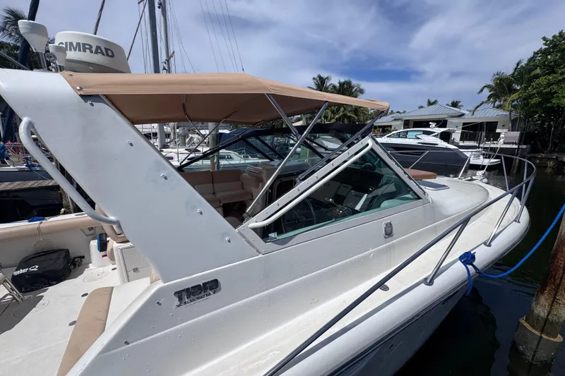 Slide: The Image of 2001 Tiara Yachts 3100 Open docked, featuring a beige canopy and sleek design. - 4