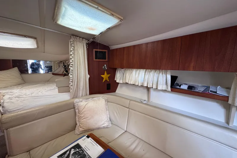 Slide: The Image of Interior of 2001 Tiara Yachts 3100 Open, featuring cozy seating and wooden cabinetry. - 40