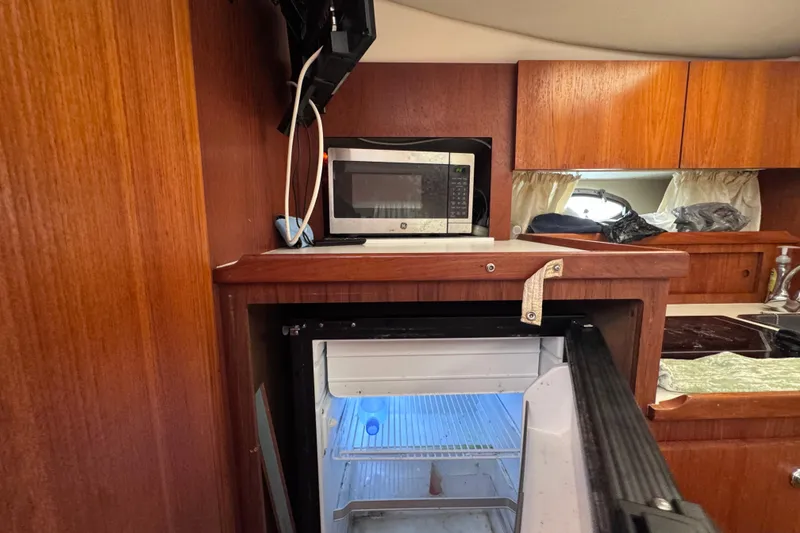 Slide: The Image of 2001 Tiara Yachts 3100 Open interior with microwave and open fridge in wooden cabinetry. - 45