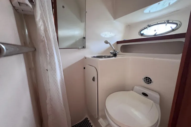 Slide: The Image of 2001 Tiara Yachts 3100 Open bathroom with sink, toilet, and porthole window. - 46