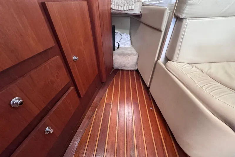 Slide: The Image of Interior of 2001 Tiara Yachts 3100 Open, featuring wood cabinetry and leather seating. - 47