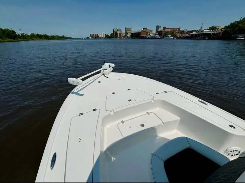 Slide: The Image of 2023 Tidewater 2110 Bay Max boat on calm river with city skyline. - 10
