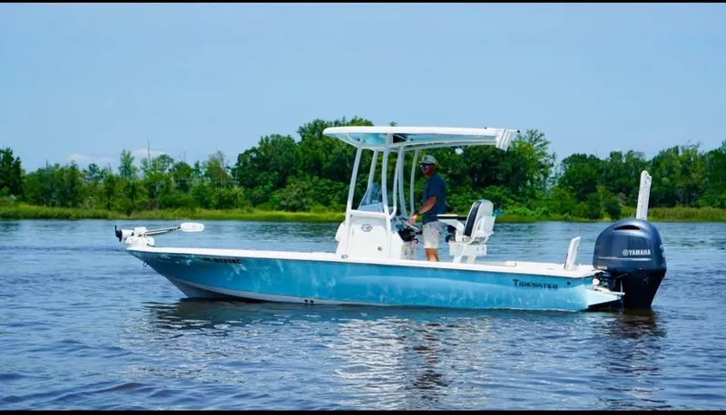 Slide: The Image of 2023 Tidewater 2110 Bay Max boat on calm water with lush greenery in the background. - 3
