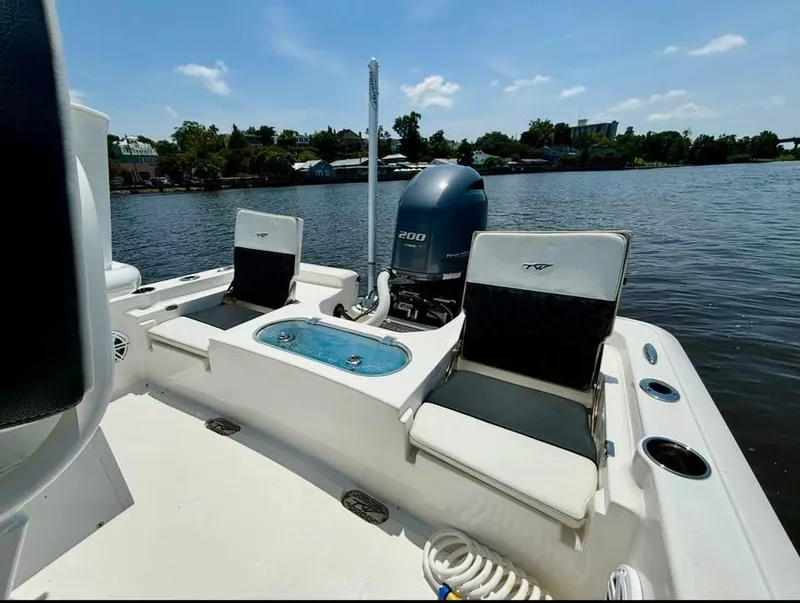 Slide: The Image of 2023 Tidewater 2110 Bay Max boat interior with seating and motor on a sunny day. - 7
