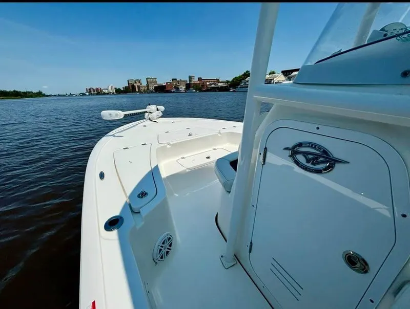 Slide: The Image of 2023 Tidewater 2110 Bay Max boat on calm water with city skyline in background. - 9
