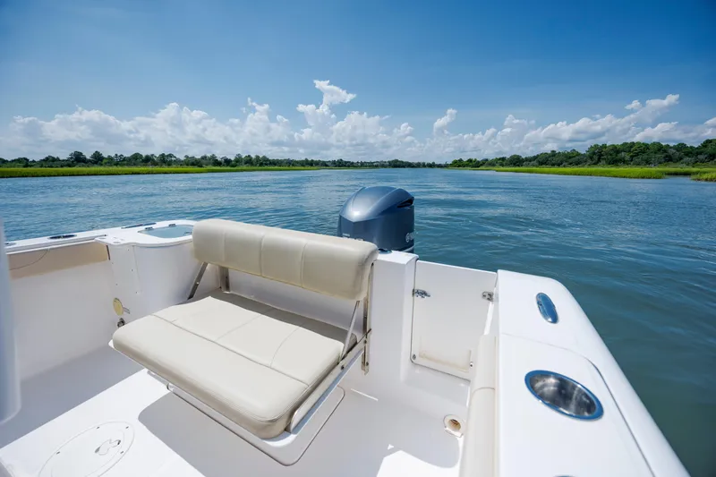 Slide: The Image of 2018 Pursuit C 238 Center Console boat on serene water with clear blue sky. - 11