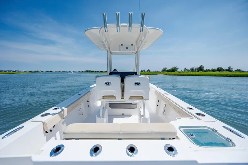 Slide: The Image of 2018 Pursuit C 238 Center Console boat on calm water, clear sky background. - 14