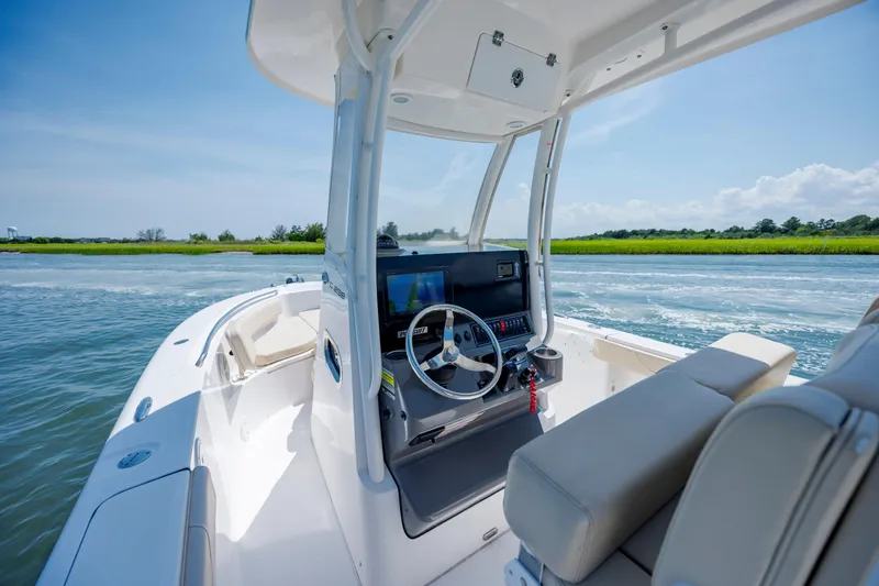 Slide: The Image of 2018 Pursuit C 238 Center Console boat on water, featuring sleek design and modern controls. - 16