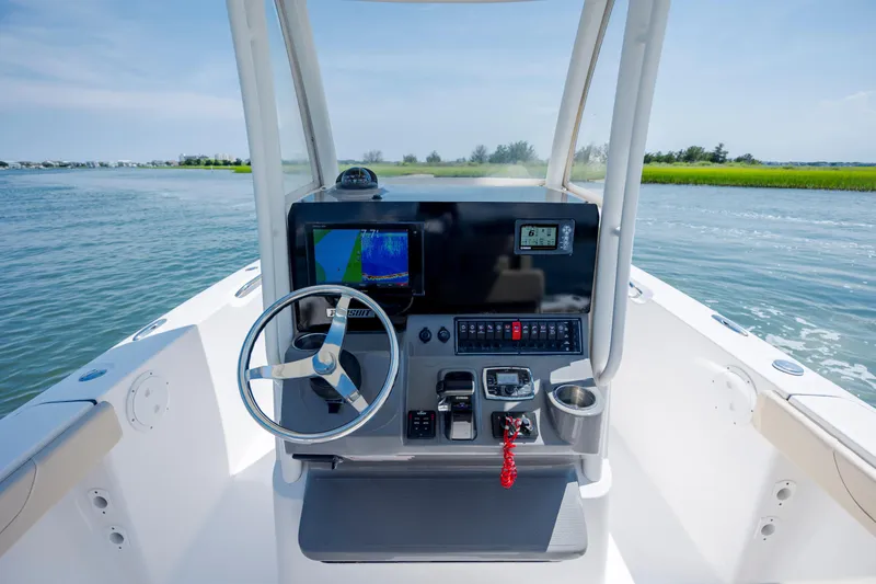 Slide: The Image of 2018 Pursuit C 238 Center Console boat dashboard with steering wheel and navigation display. - 17