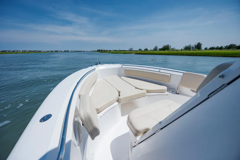 Slide: The Image of 2018 Pursuit C 238 Center Console boat on calm water, featuring comfortable seating. - 21