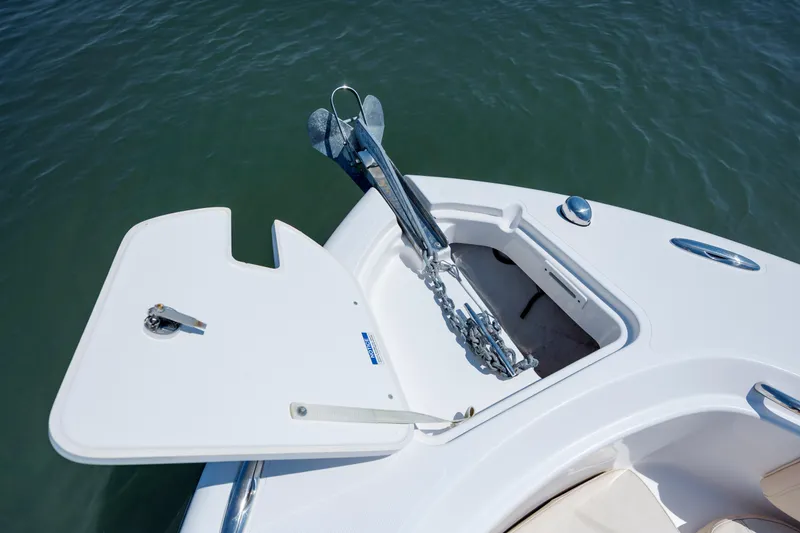 Slide: The Image of 2018 Pursuit C 238 Center Console anchor compartment with open hatch on calm water. - 23