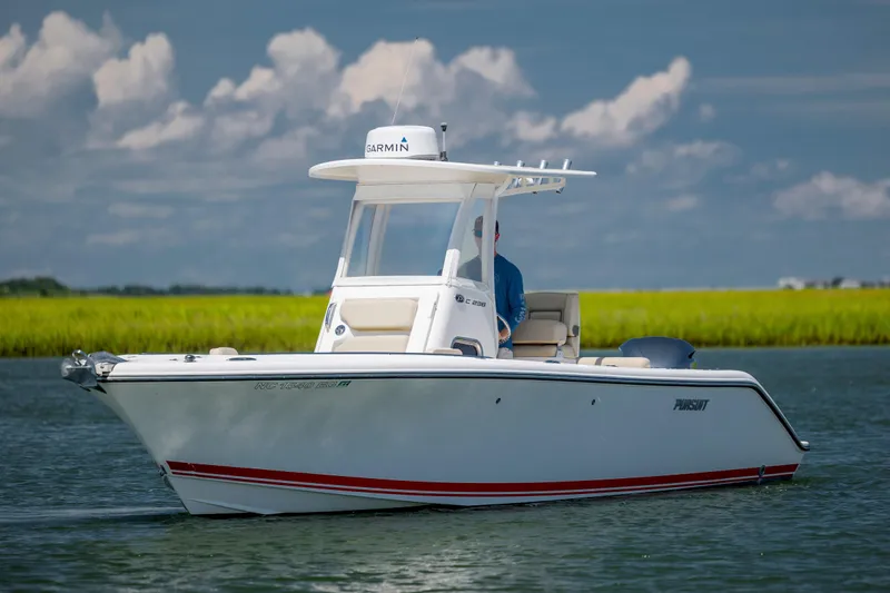 Slide: The Image of 2018 Pursuit C 238 Center Console boat on calm water under a cloudy sky. - 7