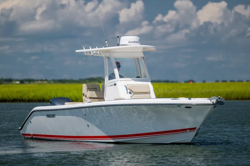 Slide: The Image of 2018 Pursuit C 238 Center Console boat cruising on calm water under a cloudy sky. - 9