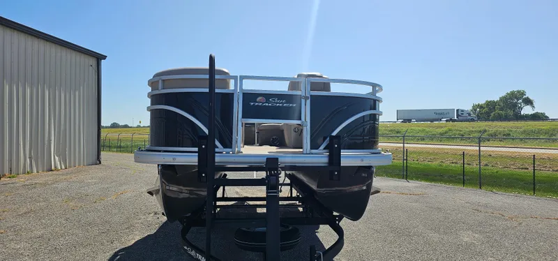 Slide: The Image of 2024 Sun Tracker SportsFish 20 DLX pontoon boat on trailer, parked outdoors. - 2