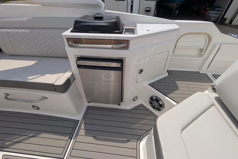 Slide: The Image of 2025 Sea Ray SDX 290 boat interior with seating, mini fridge, and sleek flooring. - 15