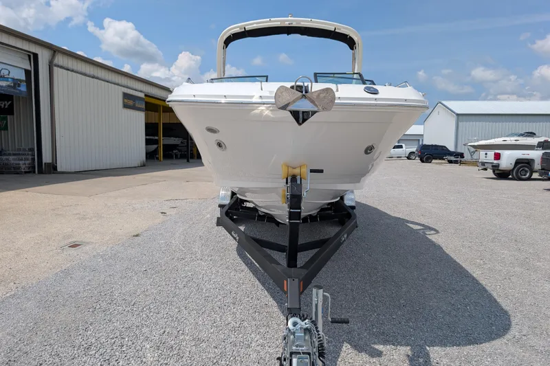 Slide: The Image of 2025 Sea Ray SDX 290 boat on trailer, parked outdoors near industrial buildings. - 2