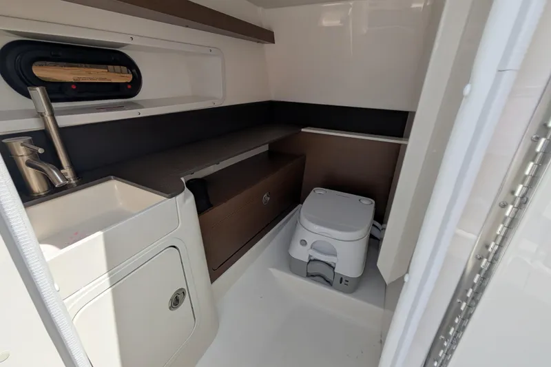 Slide: The Image of 2025 Sea Ray SDX 290 boat interior with sink and portable toilet. - 21