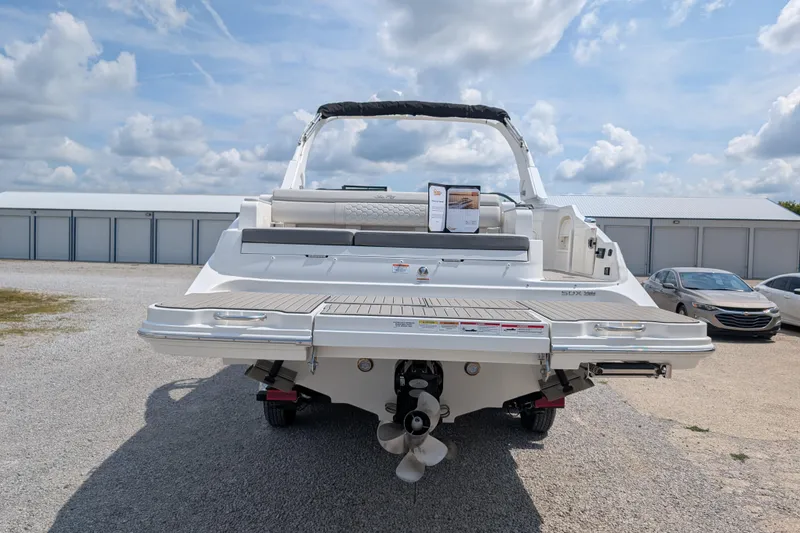 Slide: The Image of 2025 Sea Ray SDX 290 boat rear view, showcasing deck and propeller under a cloudy sky. - 6
