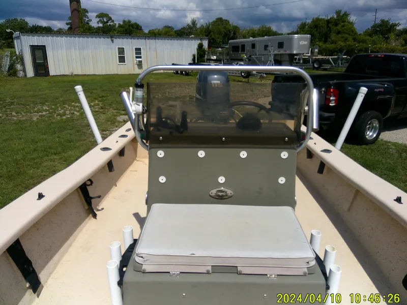 Slide: The Image of 2002 Intruder 20 Skiff boat interior with console and seating, parked outdoors. - 11