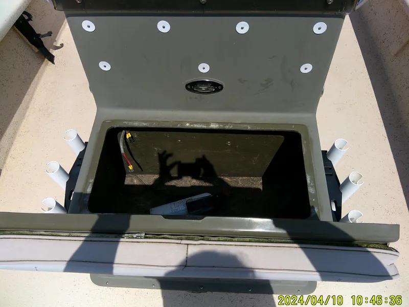 Slide: The Image of Open storage compartment on 2002 Intruder 20 Skiff boat with rod holders and wiring visible. - 12
