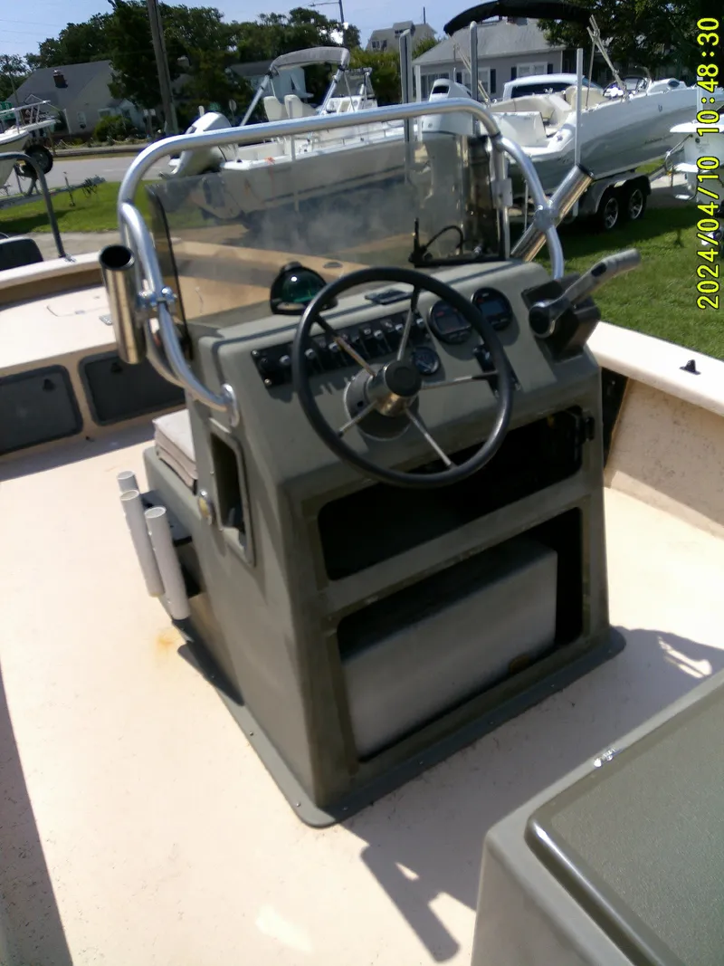 Slide: The Image of 2002 Intruder 20 Skiff boat console with steering wheel and controls. - 18