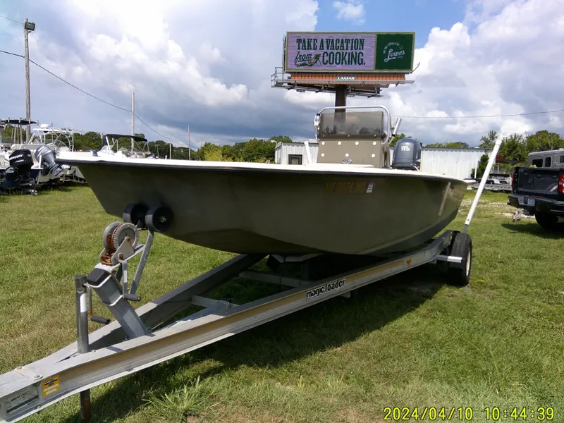 Slide: The Image of 2002 Intruder 20 Skiff boat on trailer, grassy area, overcast sky. - 2