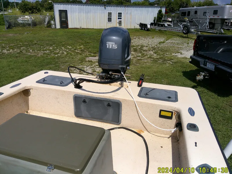 Slide: The Image of 2002 Intruder 20 Skiff with Yamaha 115 outboard motor, parked outdoors. - 20