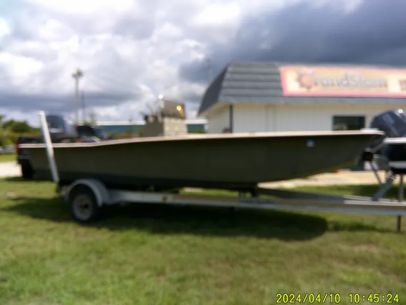 Slide: The Image of Blurry image of a 2002 Intruder 20 Skiff boat on a trailer, outdoors. - 6